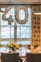 A birthday meal set up with a flower bouquet on the table and balloons.